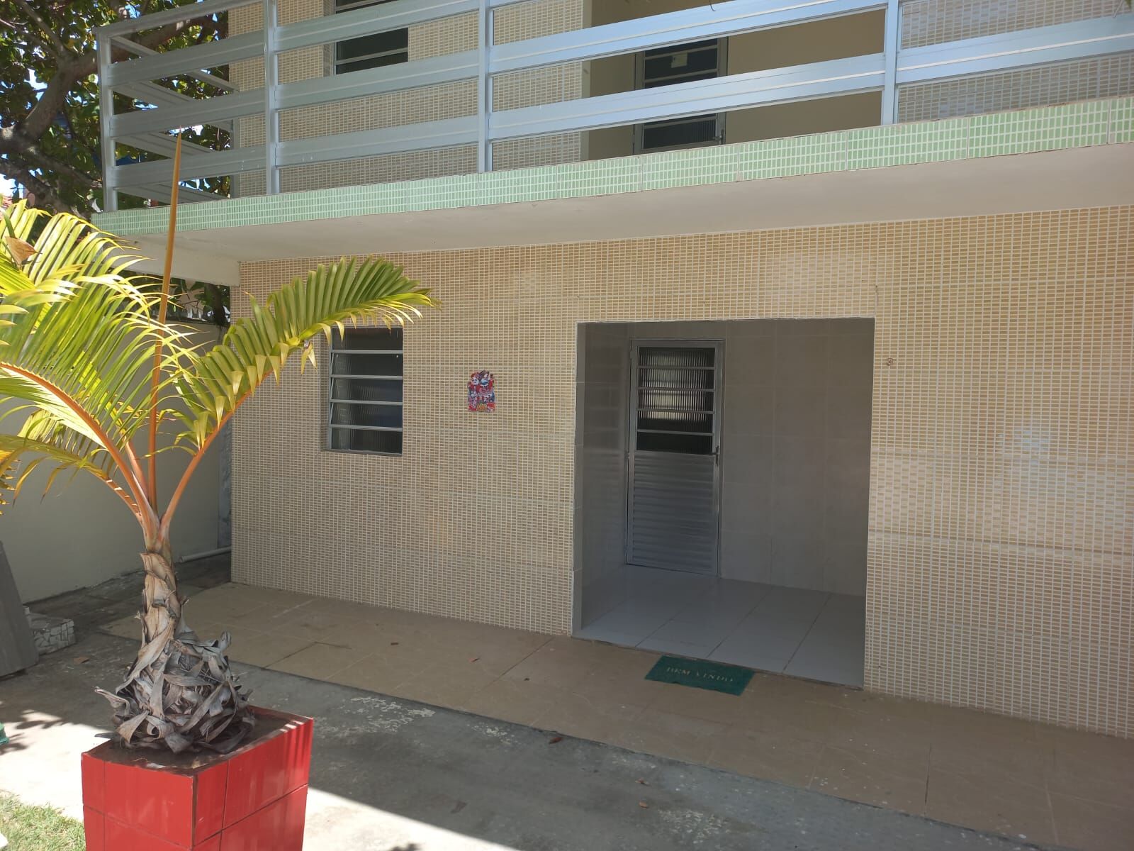 Entrada do imóvel com vaso de palmeira
