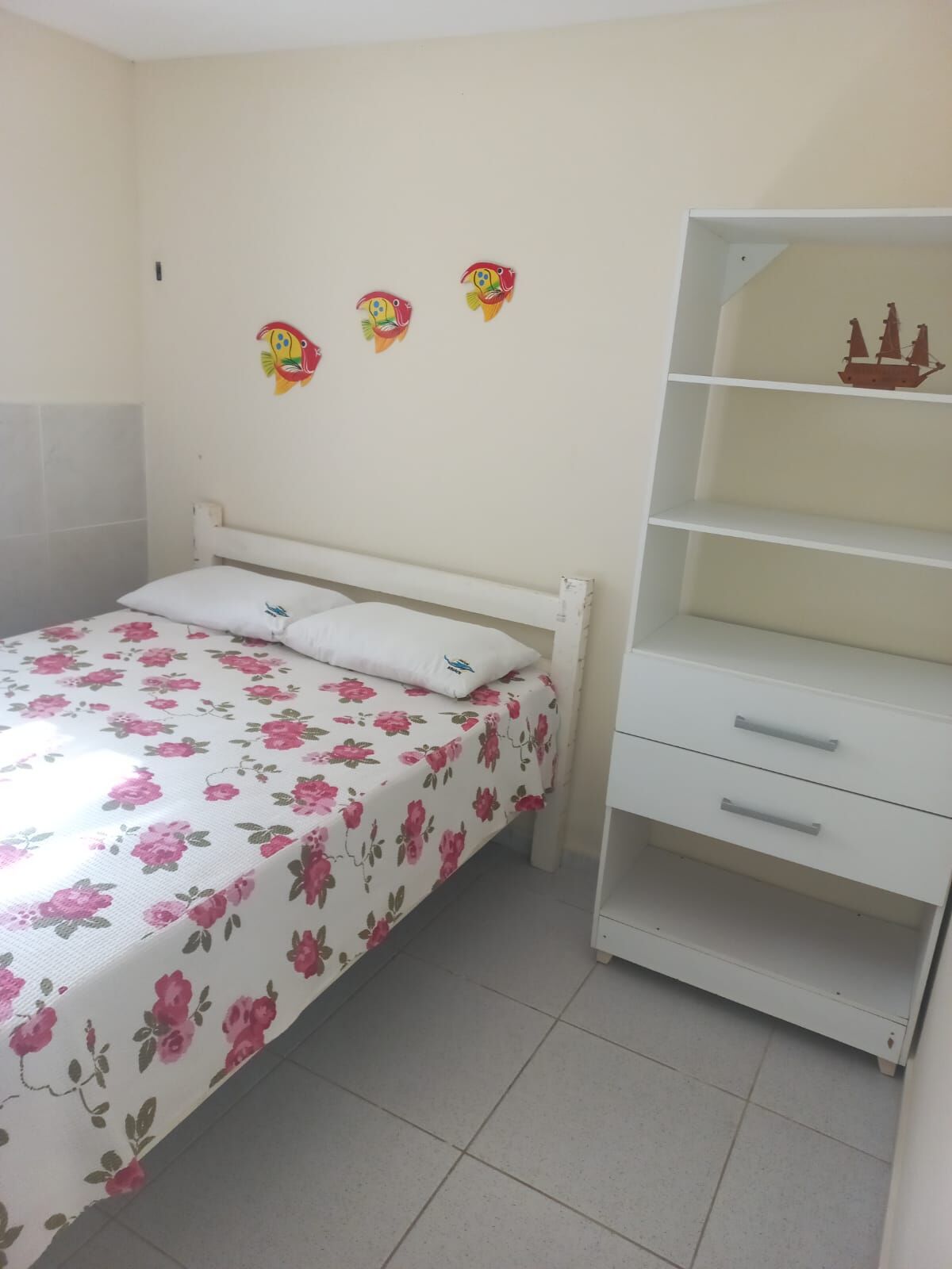Quarto com cama de casal e decoração de peixinhos
